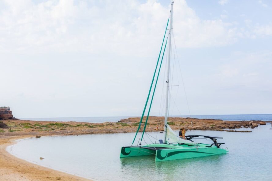 green boat with sail on the water