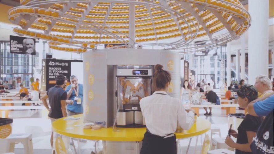woman standing in front of orange juice machine