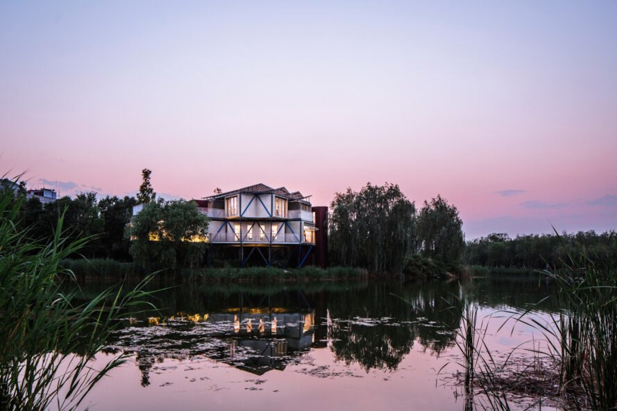 raised white building near a lake at dusk