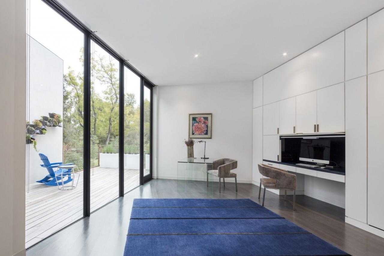 room with blue carpet, tan chairs and a glass wall