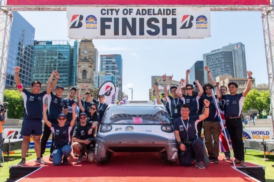 team of students near a white electric car