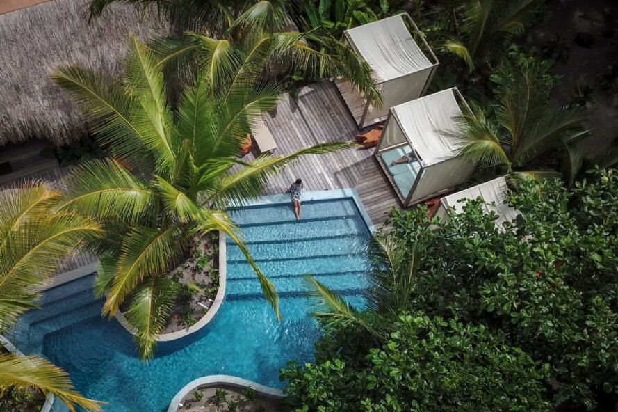 cabanas near a pool and palm trees