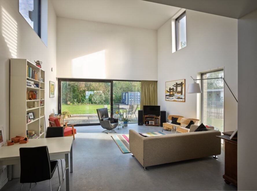 double-height white living room with beige sofa