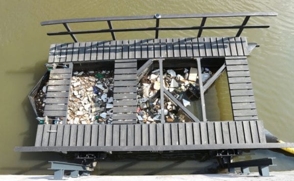 floating waste trap collecting plastic from a river