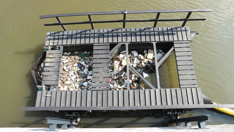 floating waste trap collecting plastic from a river