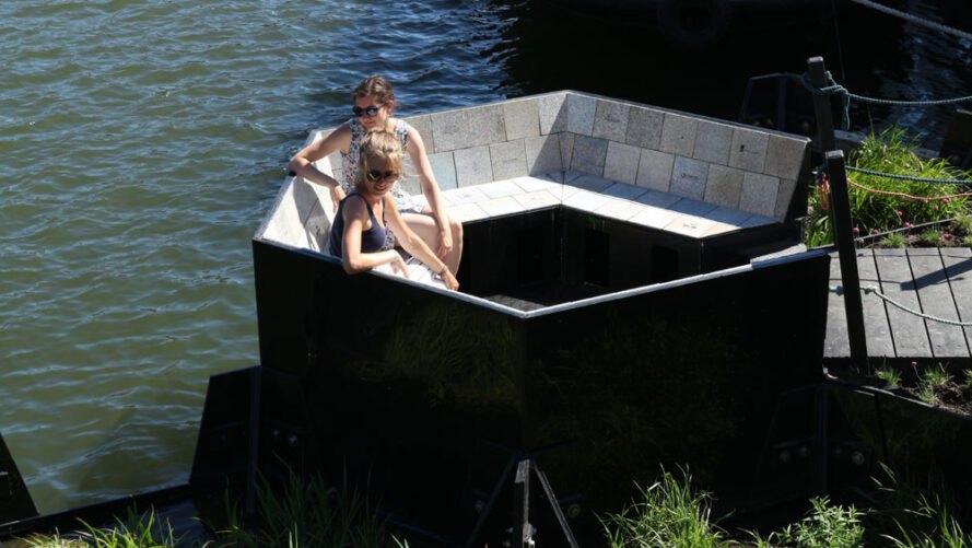 two people sitting on a floating bench