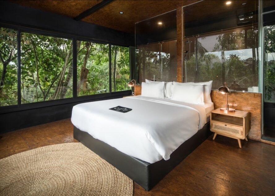 large white bed in room surrounded by windows